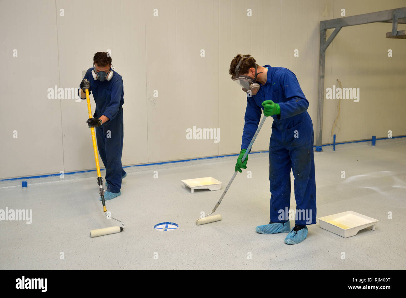 La dernière couche de roulement de métier d'époxy clair produit sur le plancher d'un bâtiment industriel Banque D'Images