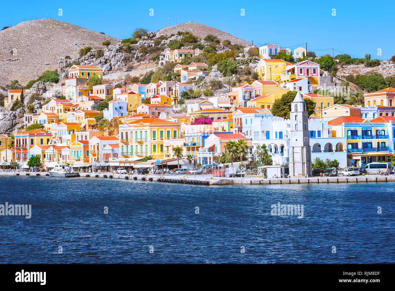 Clocher et maisons néoclassiques colorées dans la ville portuaire de Symi (île de Symi, Grèce) Banque D'Images