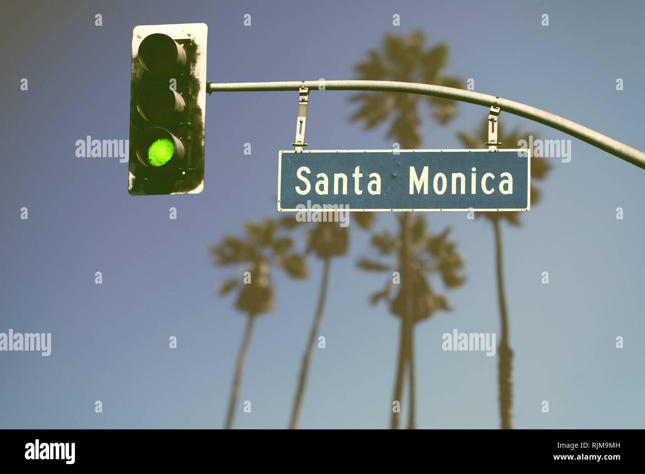 Style rétro Santa Monica Boulevard road sign avec palmiers de flou artistique en arrière-plan Banque D'Images