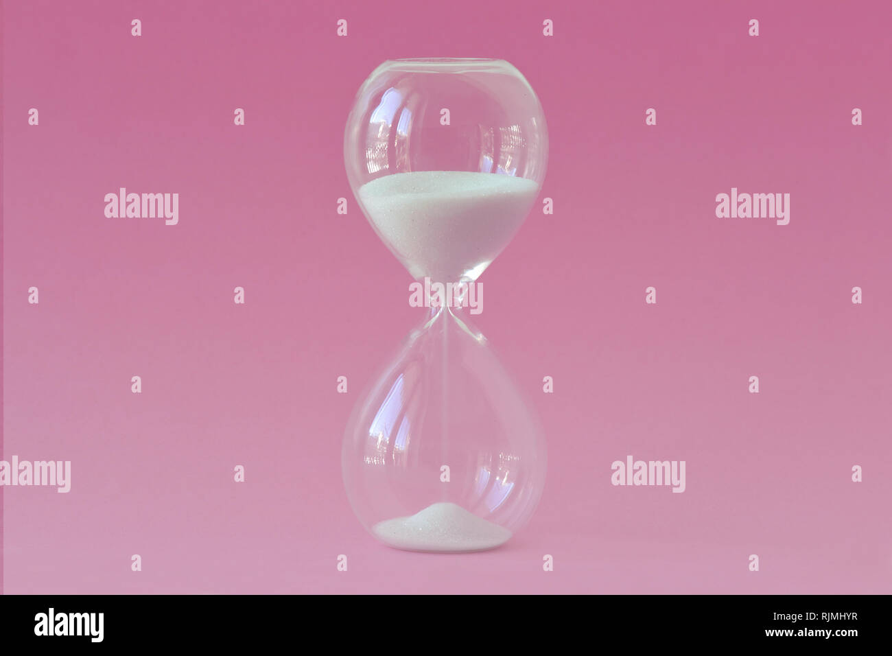 Hourglass sur fond rose - Concept de la santé, la fertilité et l'horloge biologique chez les femmes Banque D'Images