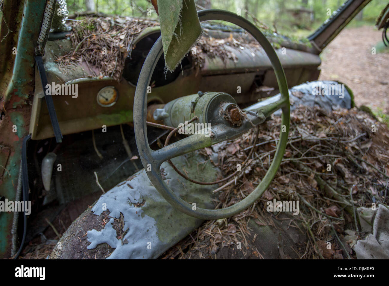 Volant de voiture rouillé vintage ancien à un parc à ferrailles à une forêt à Ryd, Kyrko Mosse en Suède Banque D'Images