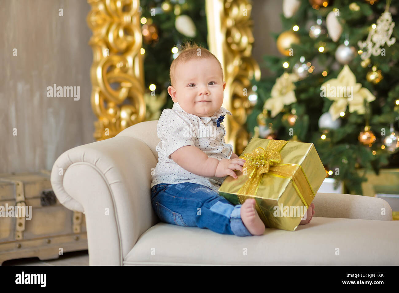 Belle petite fête Noël bébé garçon. Les jours fériés. Bébé dans un costume  de Noël les tenues avec des cadeaux sur la fourrure près de nouvelle année  tr Photo Stock - Alamy