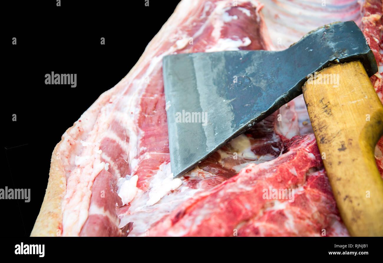 Grosse hache pour hacher la viande, la viande de la carcasse. Close up. Grosse pièce de viande. Profession Boucher Banque D'Images