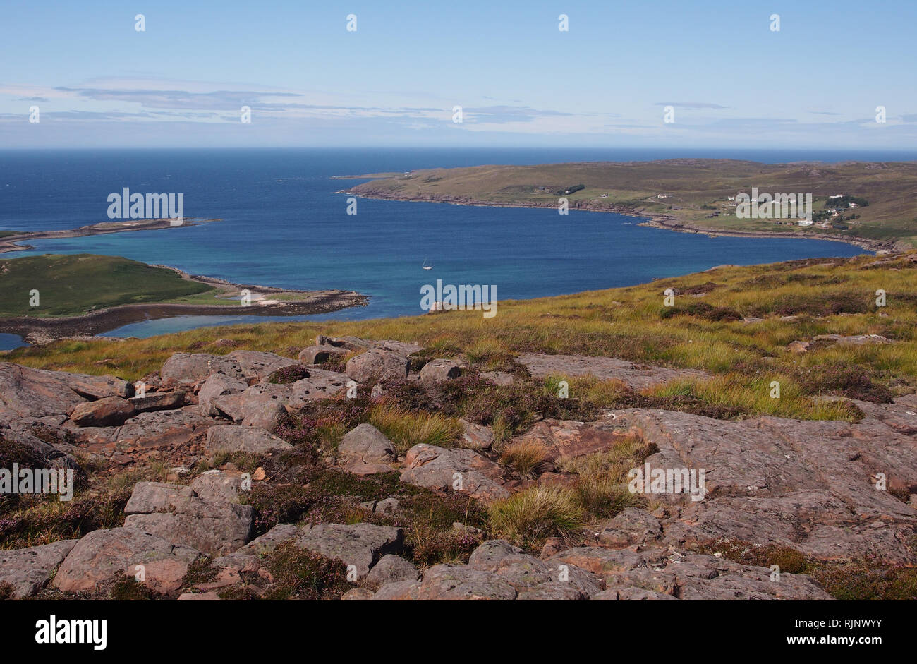 La vue sur l'Isle Ristol, Reiff et Altandhu Meail Dearg, Ecosse de avec mer bleue profonde avec des pierres et Heather à l'avant-plan Banque D'Images