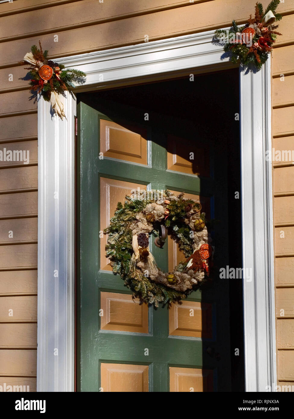 Porte en bois partiellement ouverts ; bienvenue, 2 couleurs ; couronne de Noël ; les éléments naturels, les décorations sur le châssis ; l'hiver ; vertical ; PR Banque D'Images