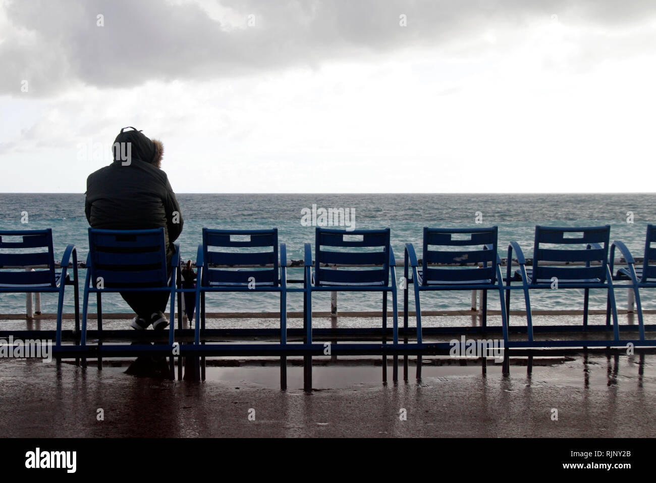 Lone personne assise sur une chaise au large de Nice, France Banque D'Images
