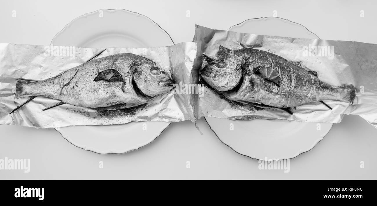 Grande image de deux la dorade poisson sur la feuille d'aluminium sur le tableau blanc - Vue de dessus de délicieux plats fait maison - retour et blanc Banque D'Images