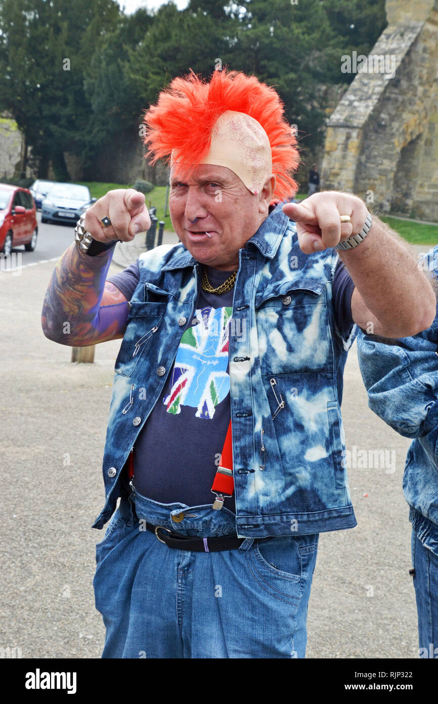 Punk Rocker sur une équipe jouant en marbres concurrentielle à l'fancy dress bon vendredi célébrations à Battle, East Sussex, England, UK Banque D'Images