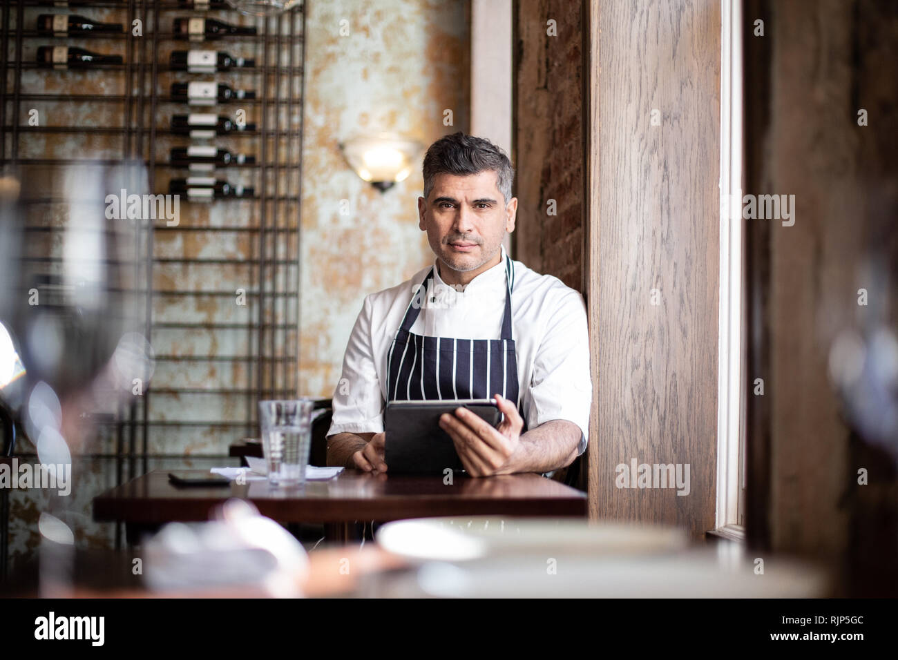 Portrait of male chef working on digital tablet in restaurant Banque D'Images