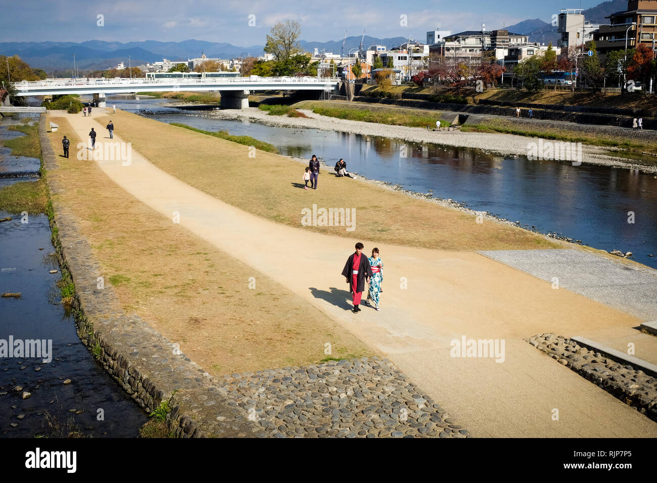 Les gens qui marchent le long de la rivière Kamogawa la ville de Kyoto, la principale voie navigable qui traverse la ville du nord au sud. Banque D'Images