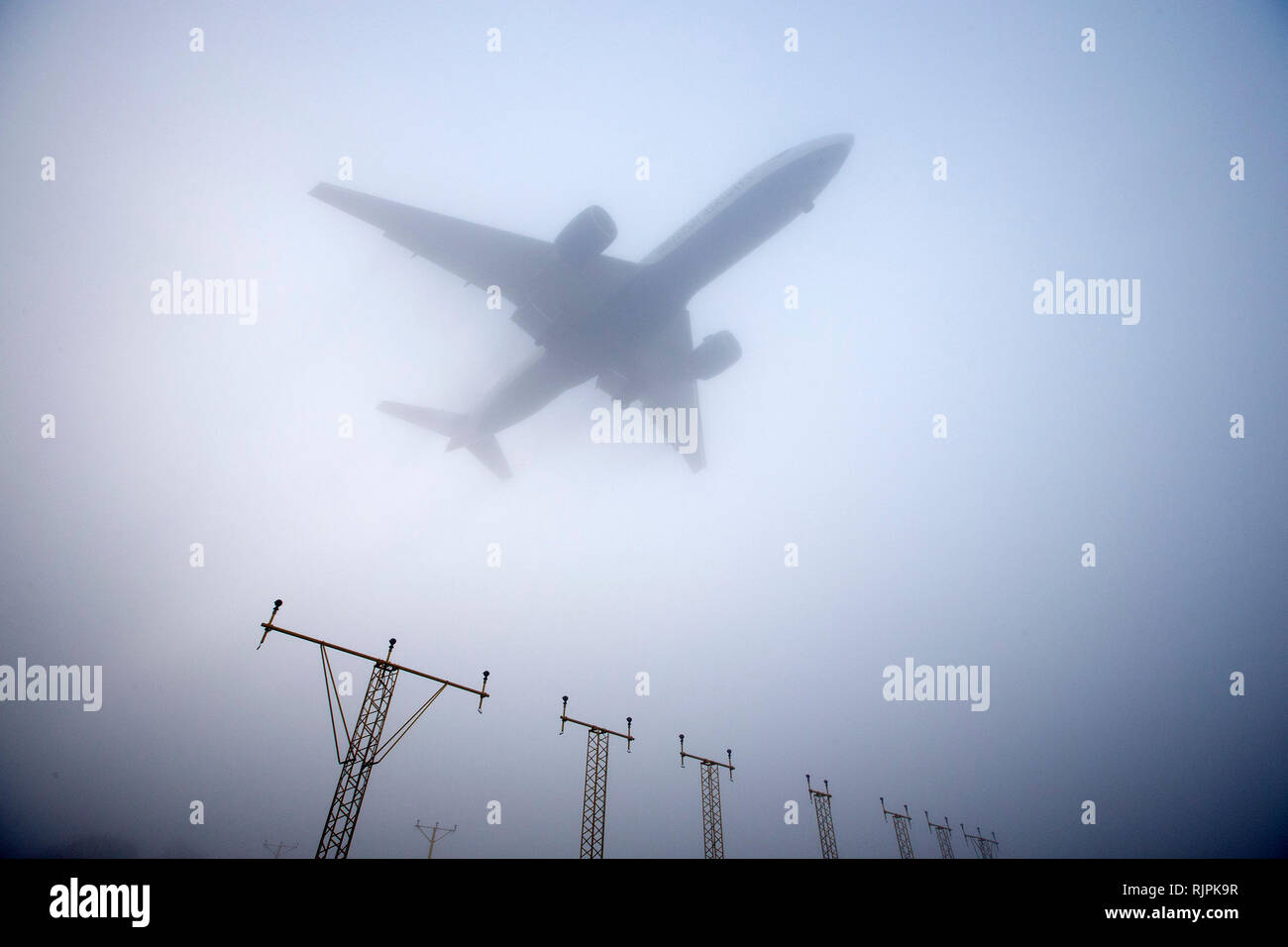 Un avion atterrit à l'aéroport Heathrow de Londres, dans un épais brouillard le 13 mars 2014. Banque D'Images