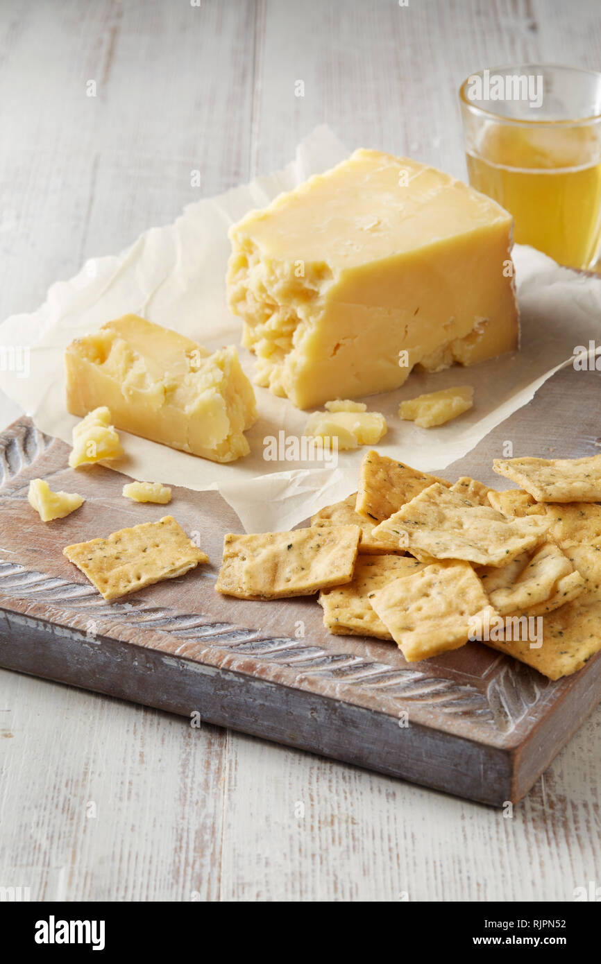 La vie toujours avec le fromage cheddar et les craquelins on cutting board Banque D'Images