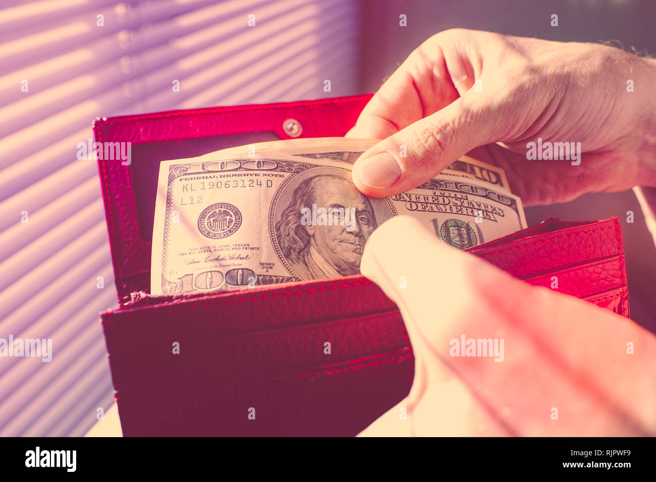 Les mains d'hommes comptant de l'argent dans un sac à main Banque D'Images