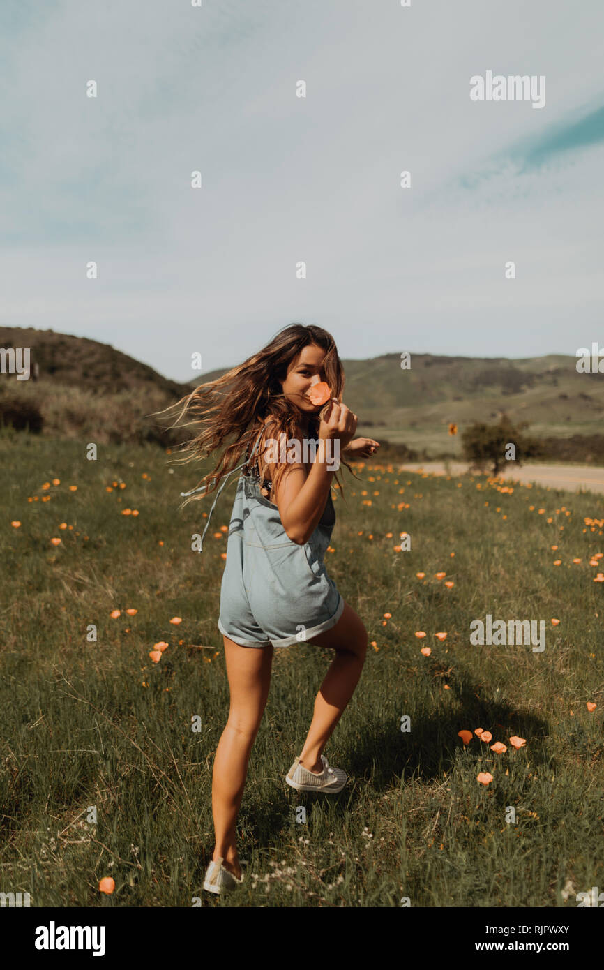 Jeune femme tournant dans le champ de fleurs sauvages, portrait, Californie, Etats-Unis, Jalama Banque D'Images