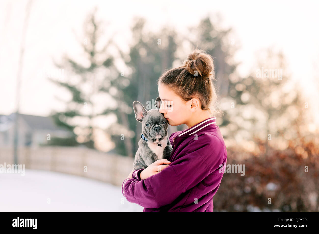 Girl kissing bouledogue français chiot à l'extérieur Banque D'Images
