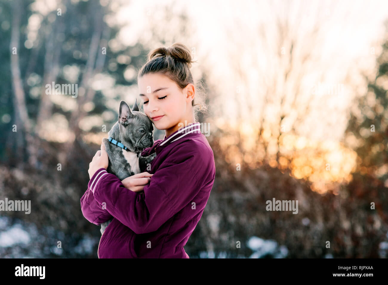 Chiot bouledogue français Girl hugging outdoors Banque D'Images