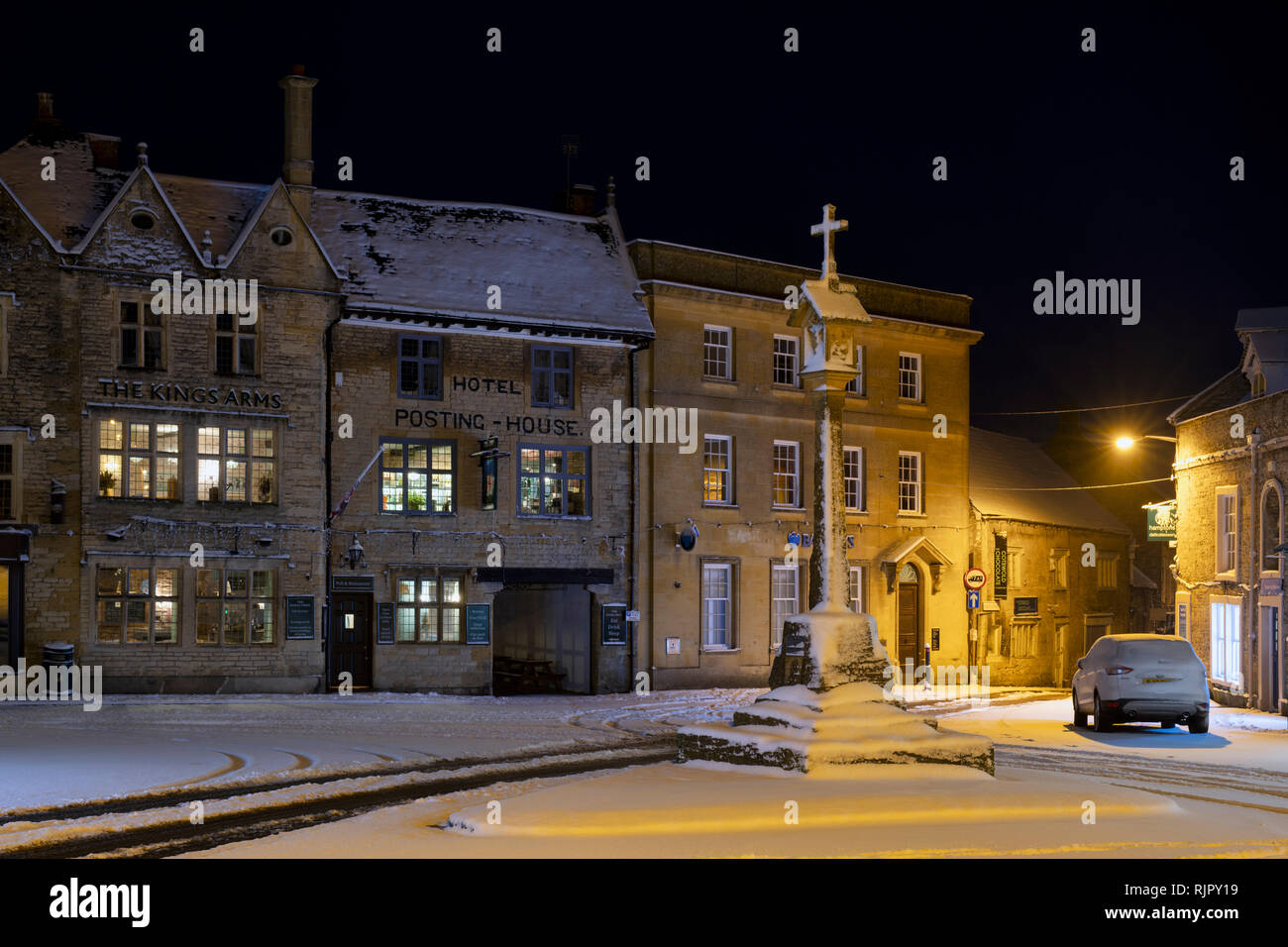 La place du marché en face de la Croix le Kings Arms pub avant l'aube dans la neige de l'hiver. Stow on the Wold, Cotswolds, Gloucestershire, Angleterre Banque D'Images