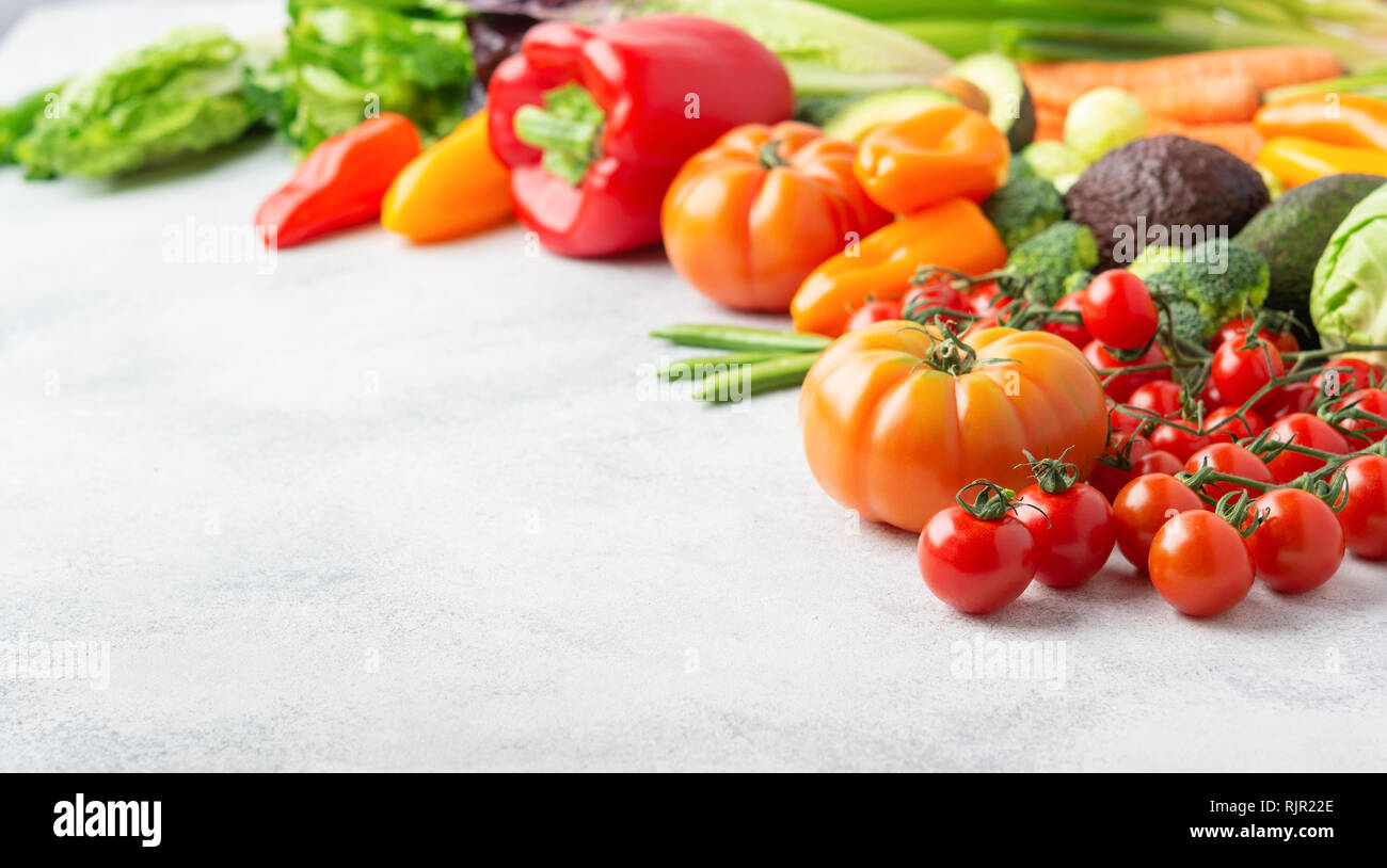Les ingrédients frais pour la salade, tomates Concombre Céleri laitue oignon poivre avocat brocoli pois sur le tableau blanc, copy space Banque D'Images