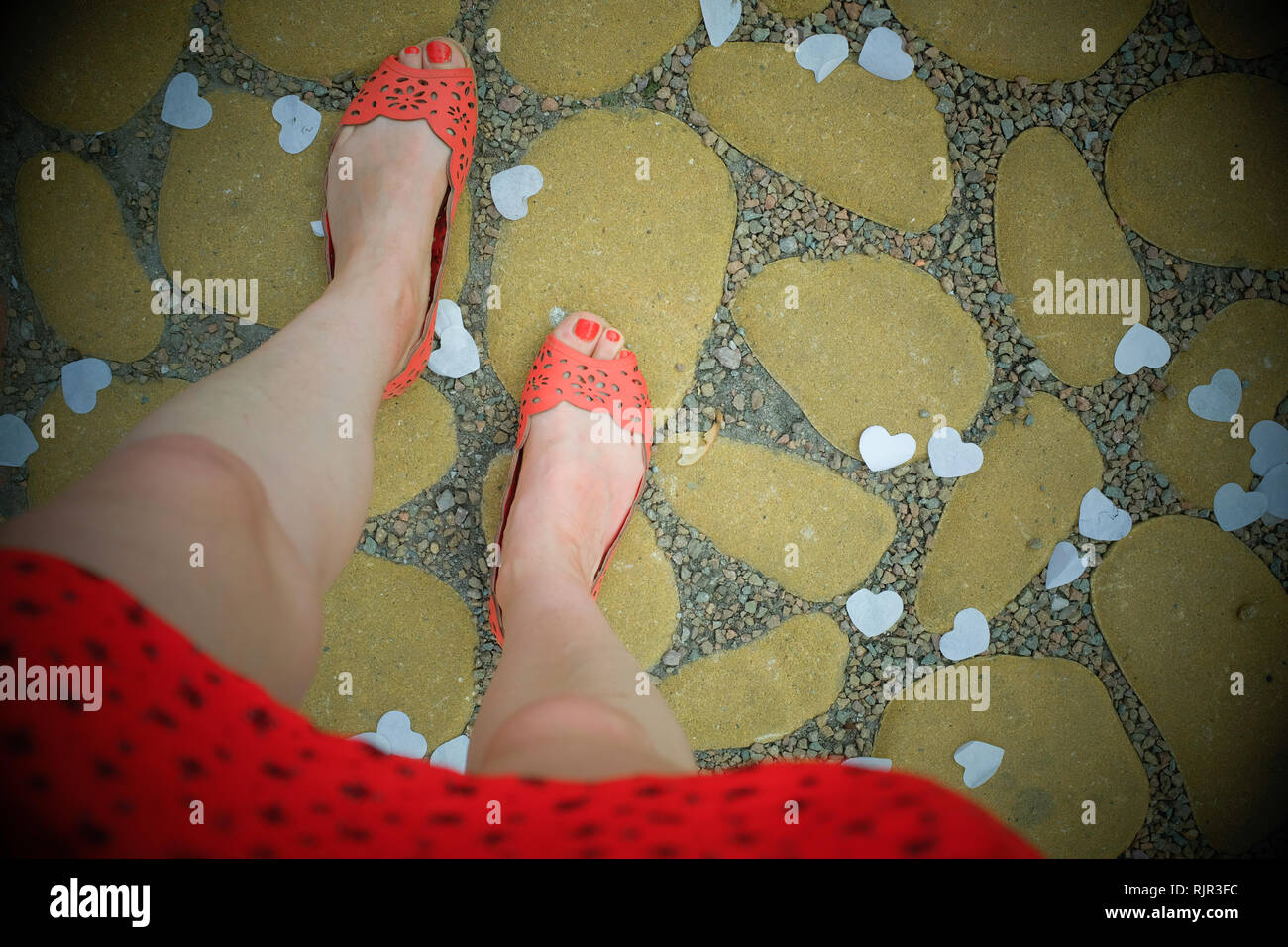 Les pieds des femmes lors d'un mariage avec des chaussures et des vêtements orange Banque D'Images