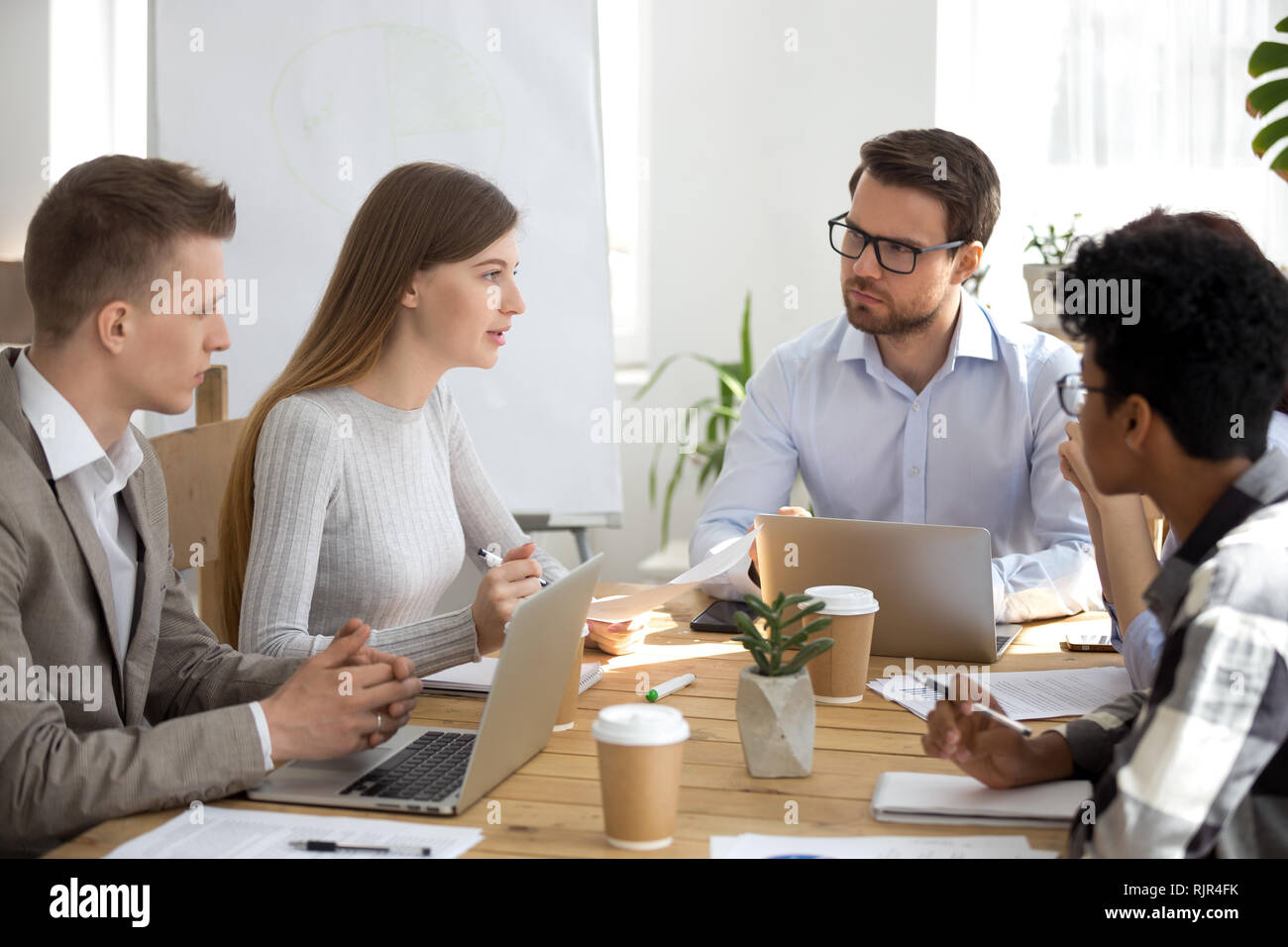 Divers collègues d'écouter un collègue parler de nouvelle idée à la réunion Banque D'Images
