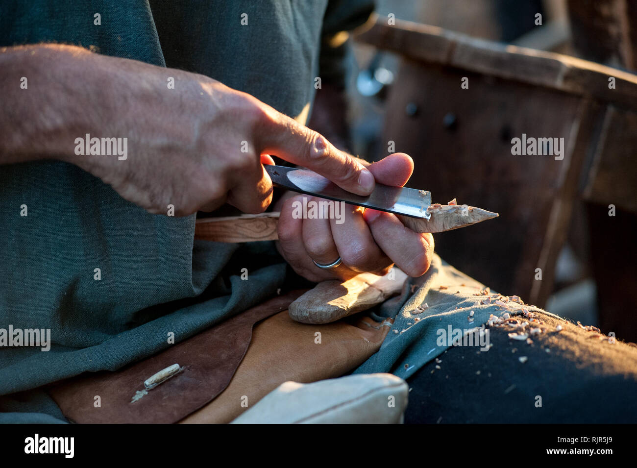 L'artisan aiguise un bâton de bois, avec une lame tranchante Banque D'Images