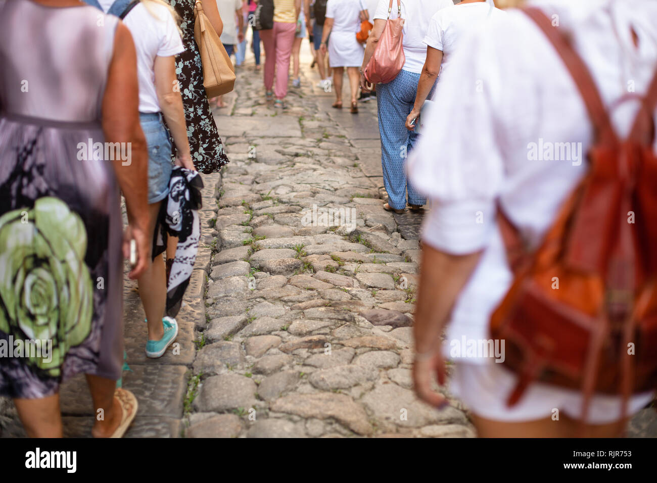 Beaucoup de gens marchent le long d'une vieille rue pavée. L'Italie, Calabre, Tropea. Groupe touristique. Vue arrière Banque D'Images