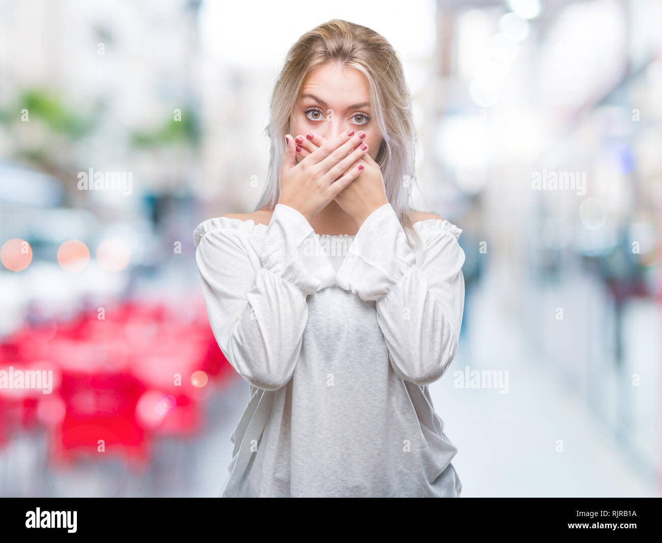 Jeune femme blonde sur fond isolé choqué couvrant la bouche avec les mains pour l'erreur. Concept Secret. Banque D'Images