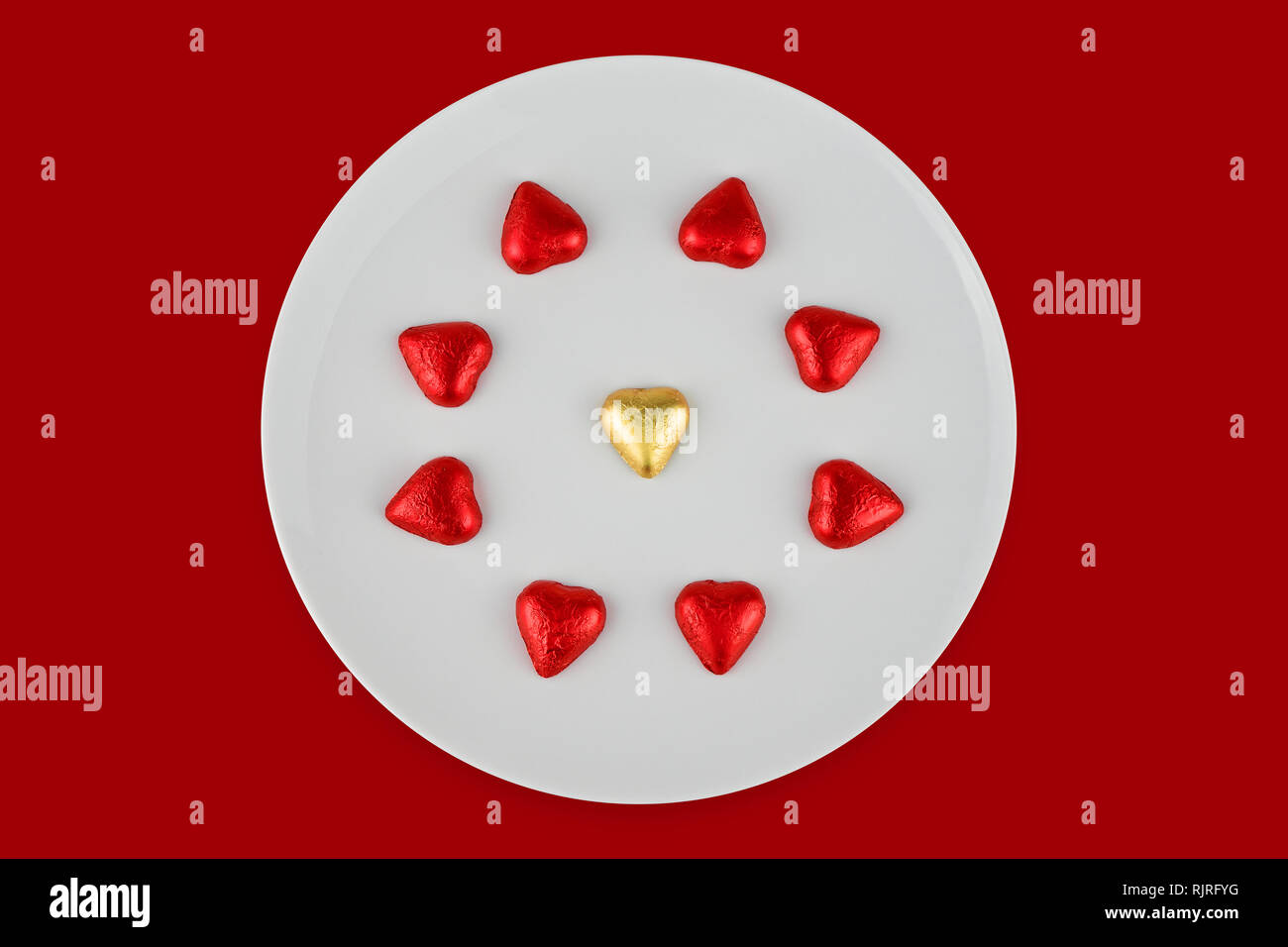 Résumé au chocolat en forme de coeur sur plaque blanche isolé sur fond rouge. Carte de voeux pour fêter la Saint-Valentin Banque D'Images