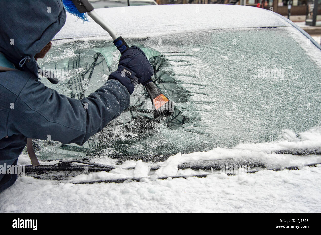 Montréal, Canada - 7 Février 2019 : voiture nettoyage de la glace du pare-brise avec grattoir outil. Banque D'Images