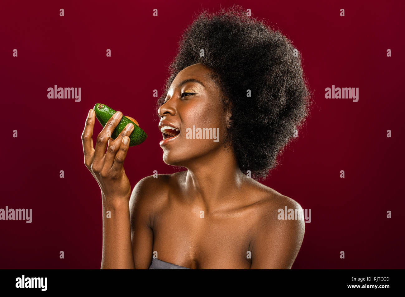 Femme belle de manger un avocat Banque D'Images