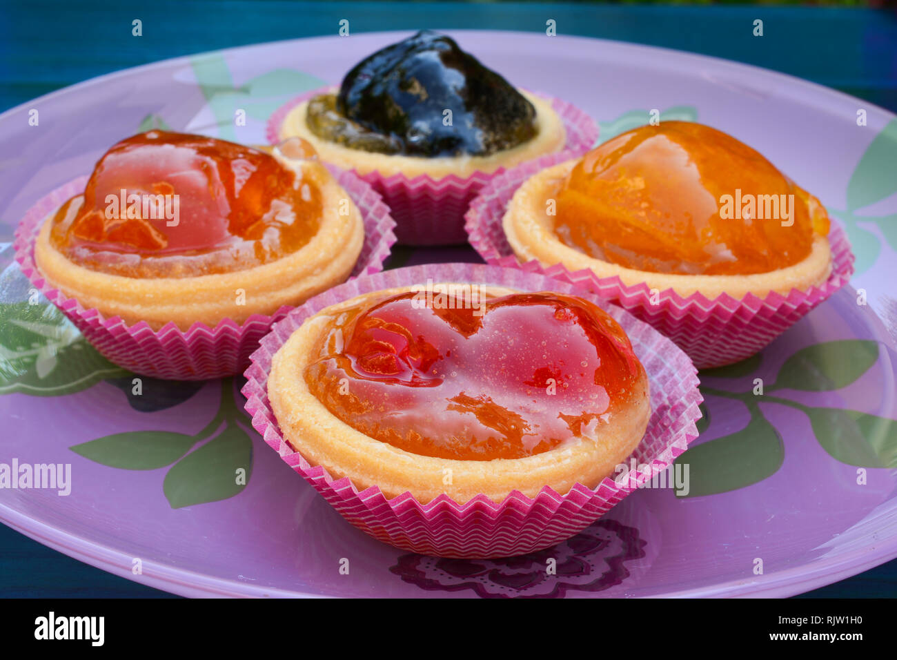Pâte de barquettes rempli avec divers fruits confits, servi dans la plaque de verre rose, Close up, side view Banque D'Images