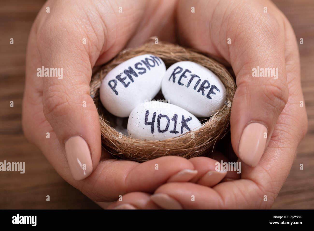 Close-up of Human Hand Holding Nest avec pension de retraite anticipée, le texte et les oeufs 401k Banque D'Images