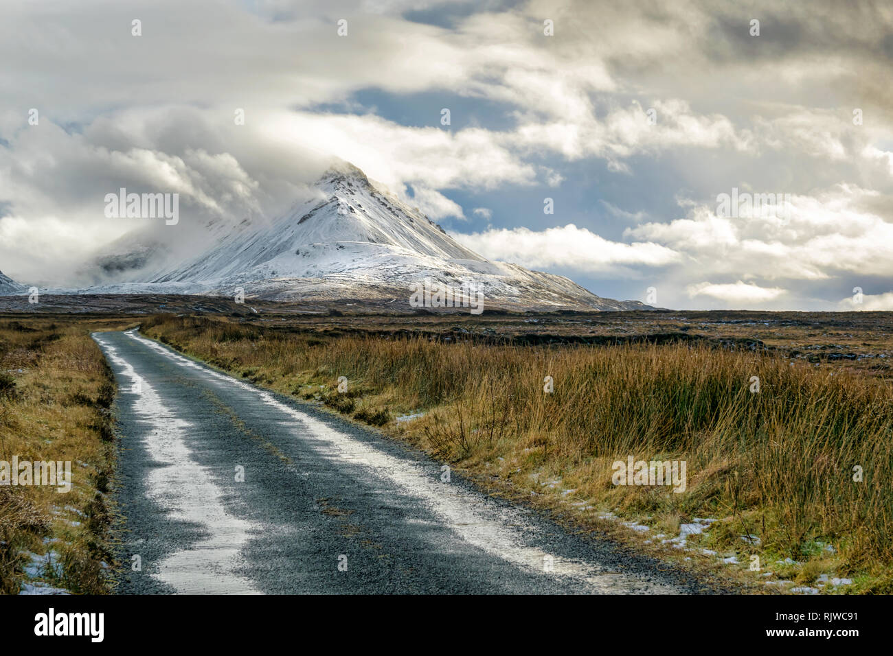 Photo d'une route de montagne à distance aller à la montagne couverte de neige Errigal à Donegal en Irlande. Banque D'Images