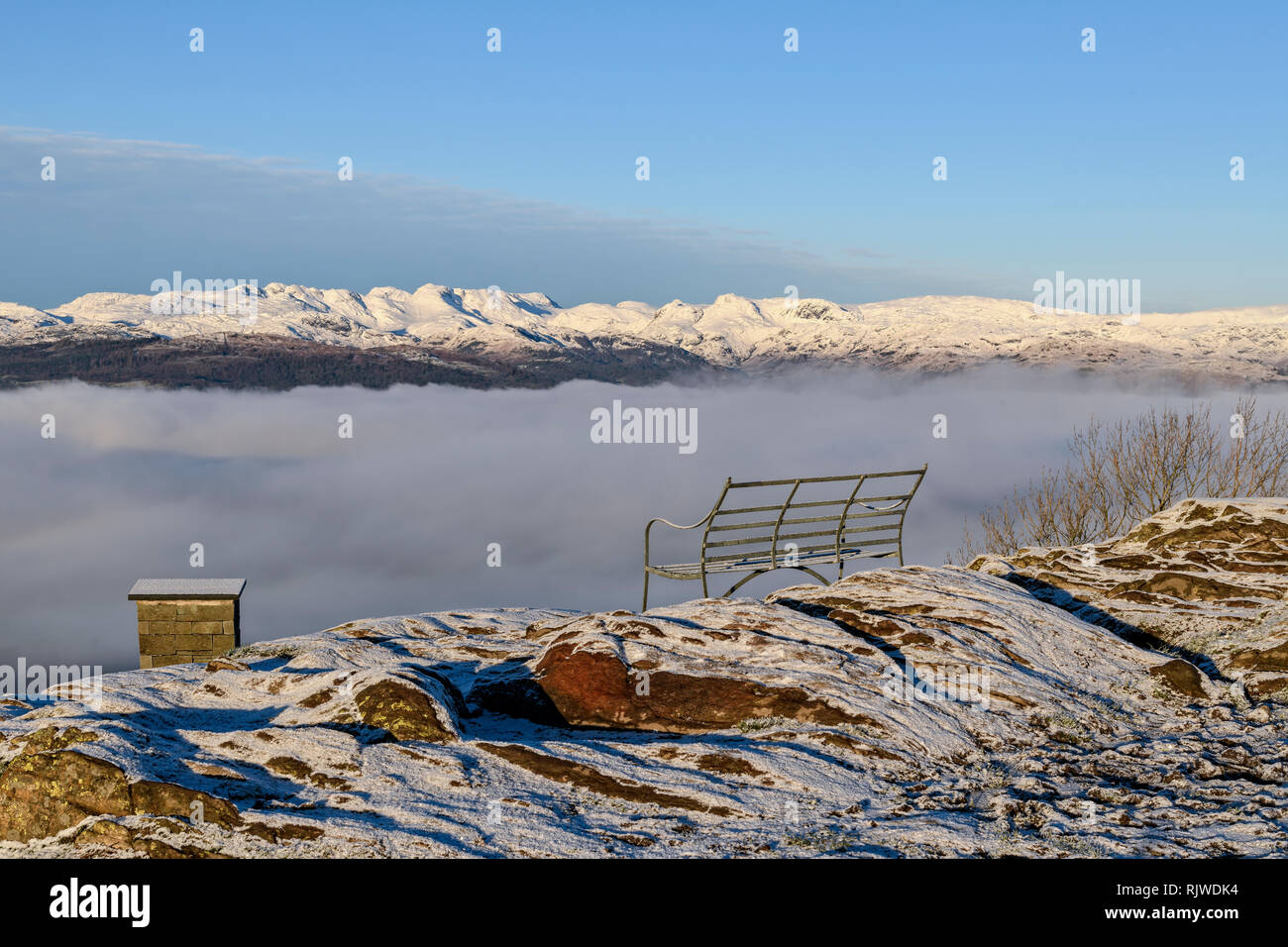 Un siège avec une vue. Une vue imprenable au-dessus de la nuée inversion de la lande couverte de neige d'Orrest Head près de Windermere Banque D'Images