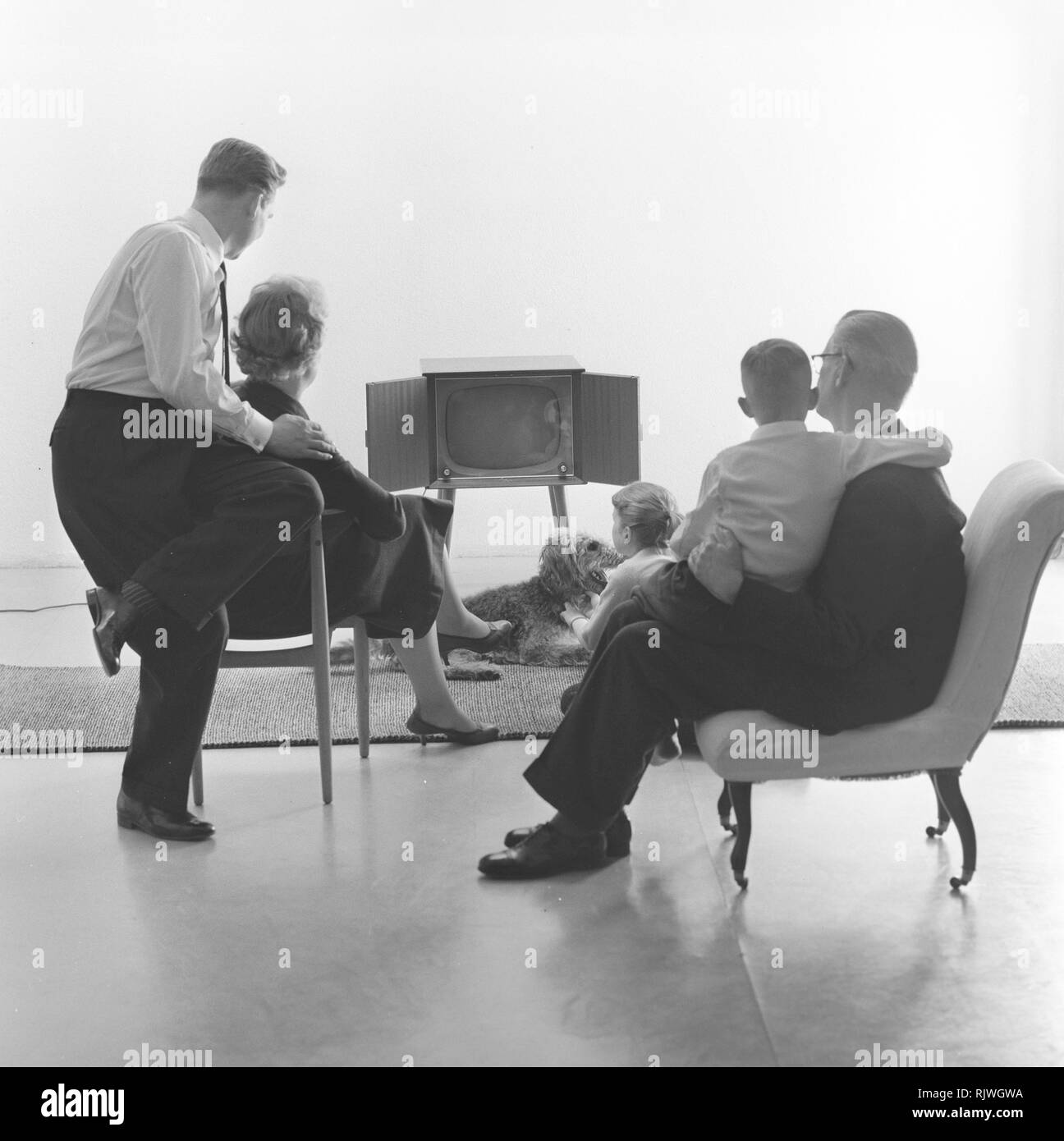 La télévision dans les années 1950. Famille devant un téléviseur et fasciné par le nouveau moyen de la télévision en mars 1959. La Suède Banque D'Images La télévision dans les années 1950. Famille devant un téléviseur et fasciné par le nouveau moyen de la télévision en mars 1959. La Suède Banque D'Images