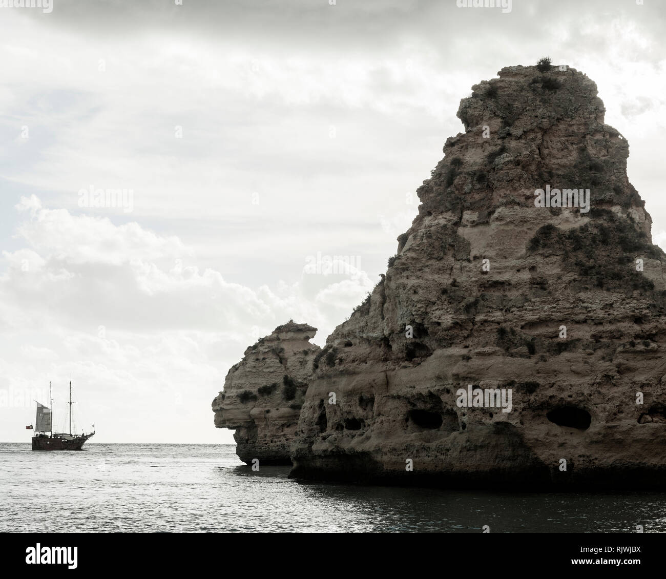 Bateau à voile Vintage par de gros rochers en mer, Praia da Marinha, Algarve, Portugal, Europe Banque D'Images