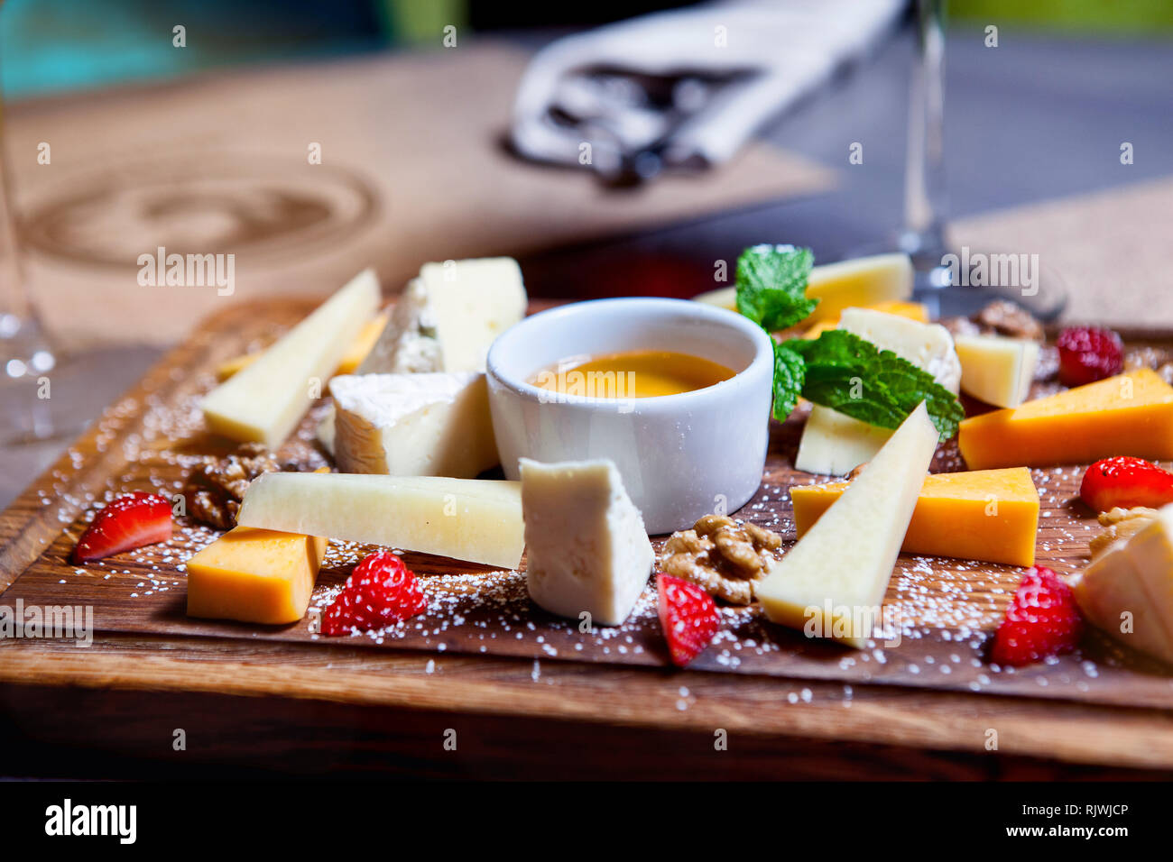 Assiette de fromage servi avec des raisins, miel et noix sur un fond de bois. Différents types de fromage Banque D'Images