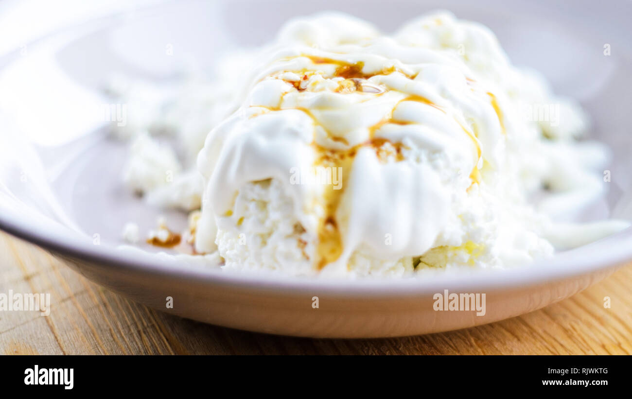 Le fromage cottage blanc avec le caramel. Dessert avec du fromage blanc, de crème et de caramel Banque D'Images