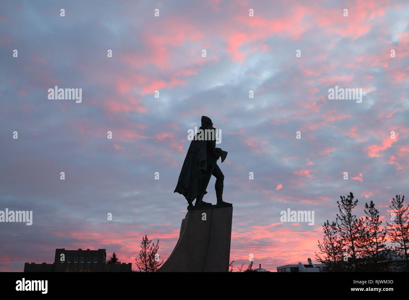 VOR der Hallgrimskirkja steht die Statue von Leif Eriksson.Hier mit der Streitaxt vor rotem abendhimmel Banque D'Images