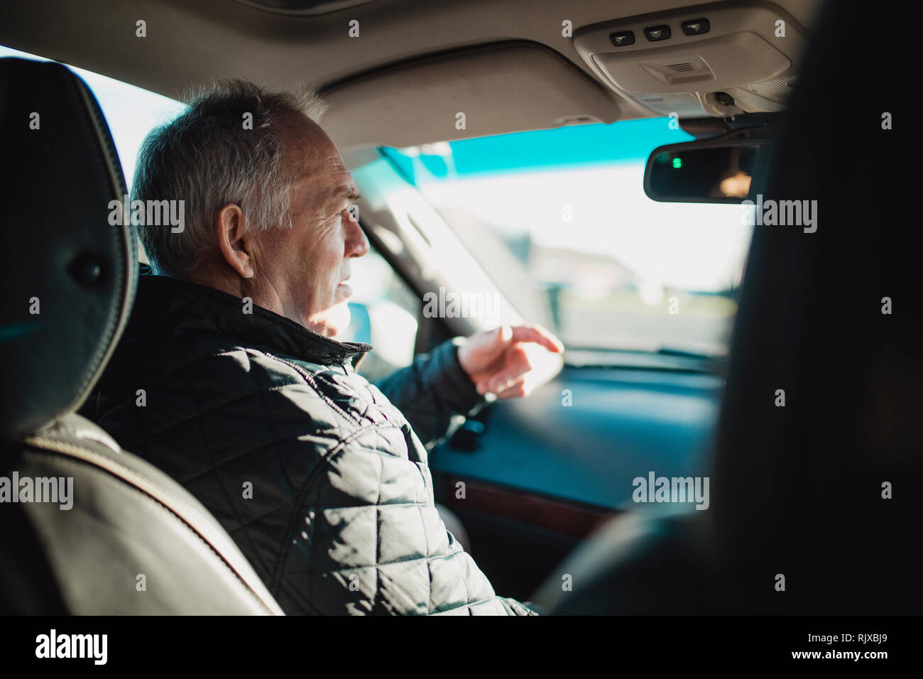 Man est assis dans le siège passager d'une voiture, parler au chauffeur qui ne peut pas être vu dans le cadre. Banque D'Images