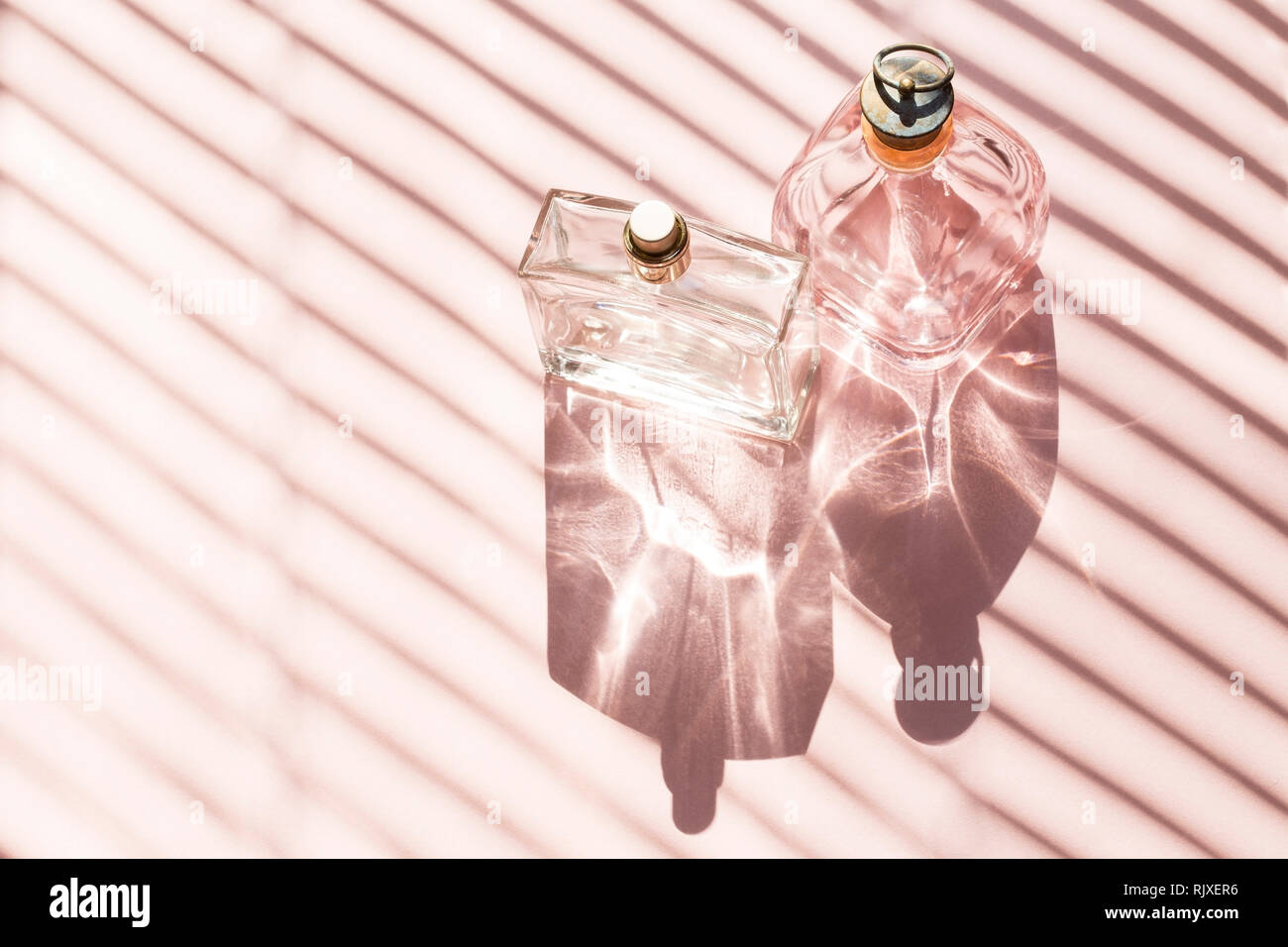 Flacons de parfum sur une lumière vive avec l'ombre Banque D'Images