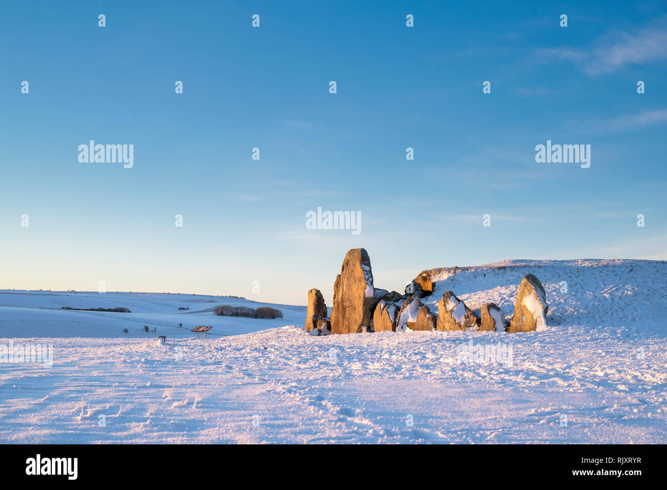 West Kennet Long Barrow dans la neige de l'hiver au lever du soleil. Chambré néolithique tombe. West Kennet, Wiltshire, Angleterre. Banque D'Images