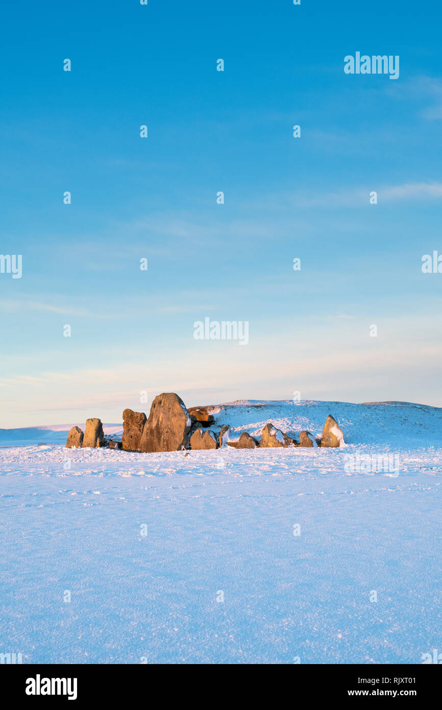 West Kennet Long Barrow dans la neige de l'hiver au lever du soleil. Chambré néolithique tombe. West Kennet, Wiltshire, Angleterre. Banque D'Images