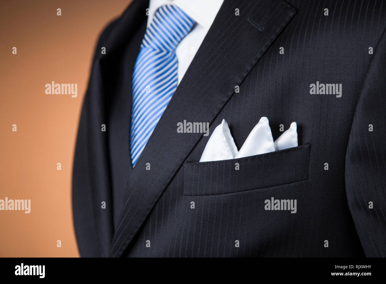 Close up d'un mouchoir de poche blanc plié avec trois points dans la poche  d'un poing américain noir costume avec une cravate bleue et orange  background Photo Stock - Alamy