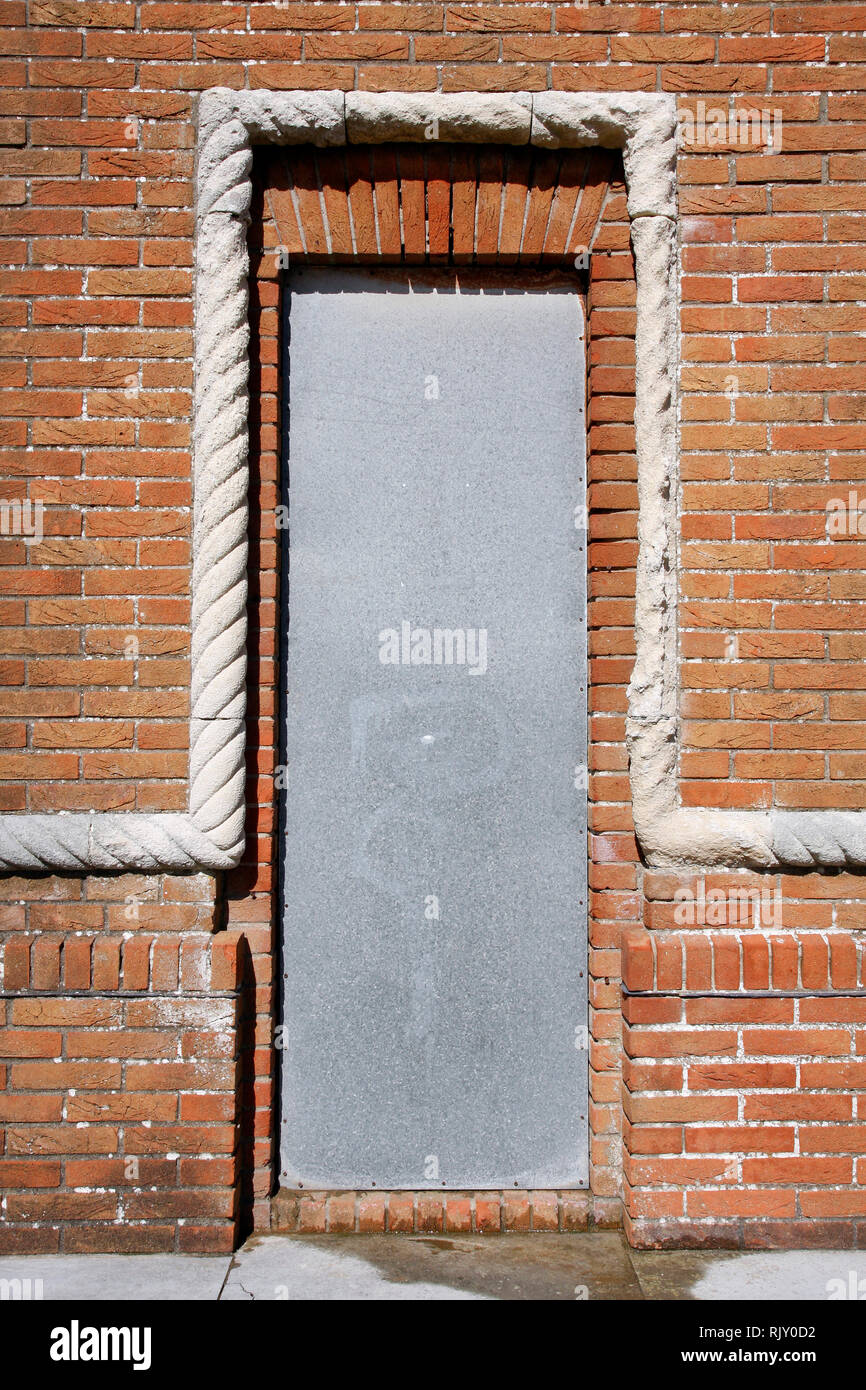 Mur en briques anciennes en pierre avec motif corde détail autour d'un couvercle de sécurité métallique avec porte Banque D'Images