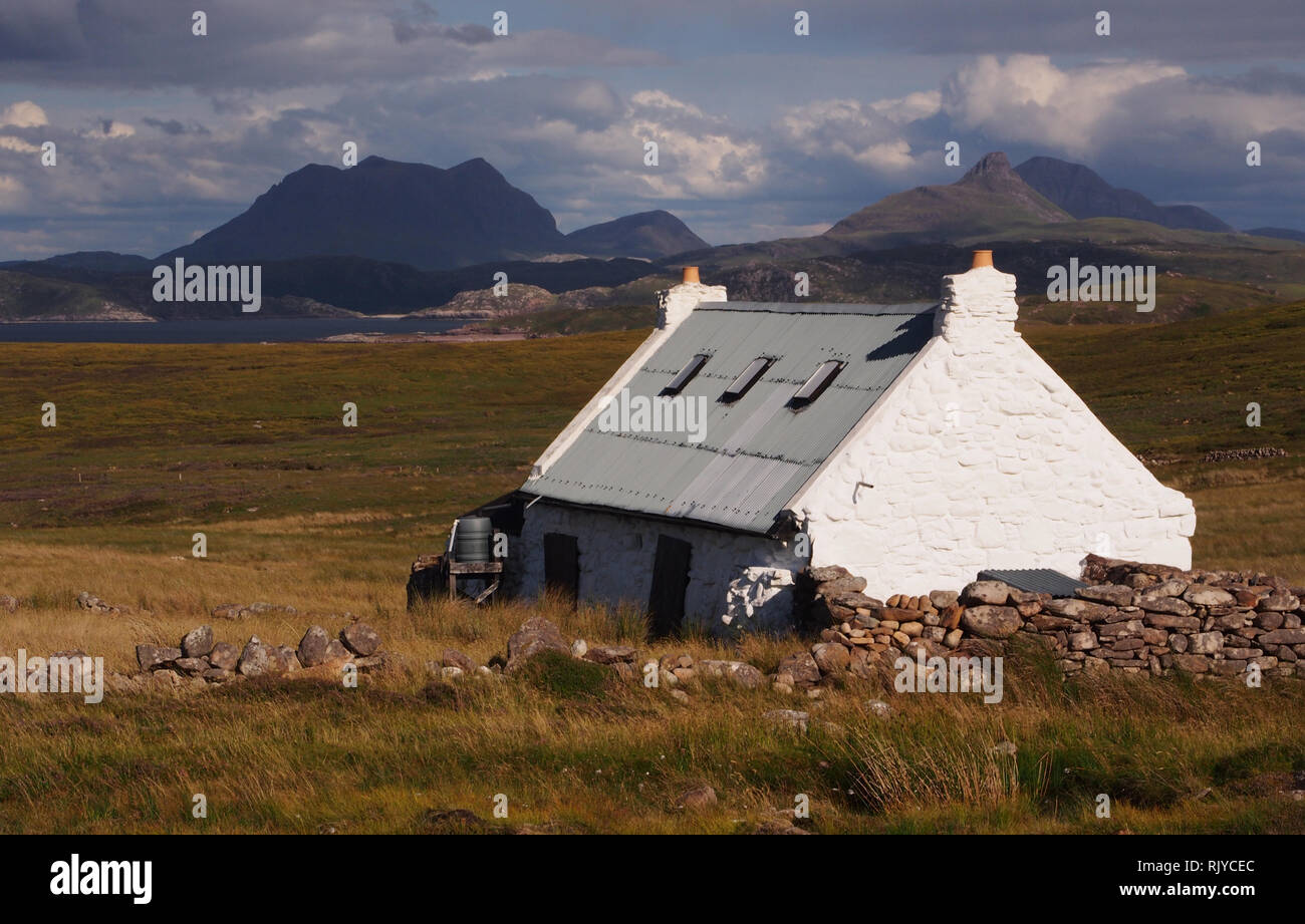 Une vue de la vieille et crofters home après quelques rénovations, situé loin des routes sur la péninsule, l'Écosse et Coigach montagnes en arrière-plan Banque D'Images