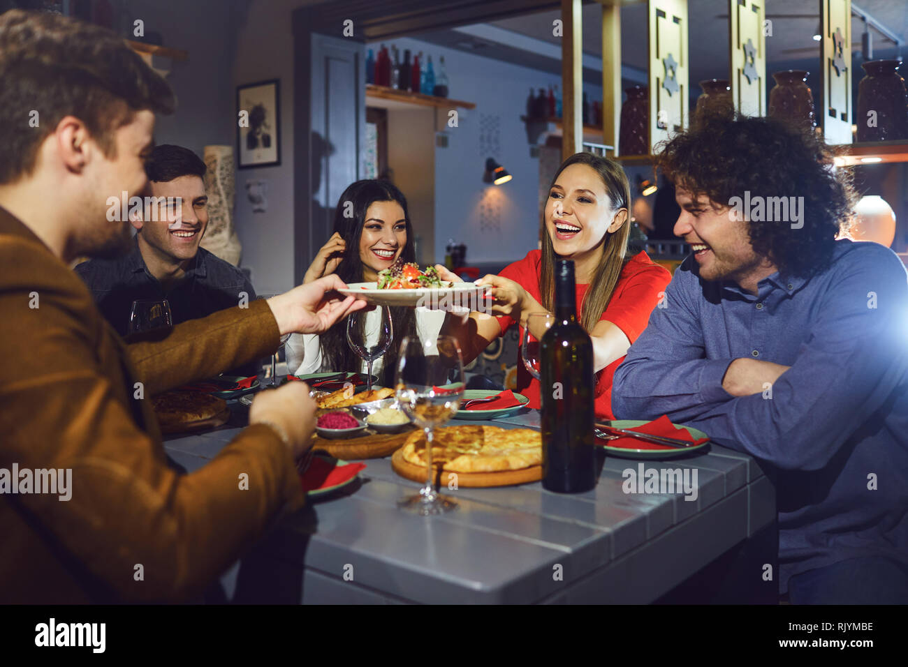 Un groupe d'amis à manger un dîner dans un restaurant. Banque D'Images