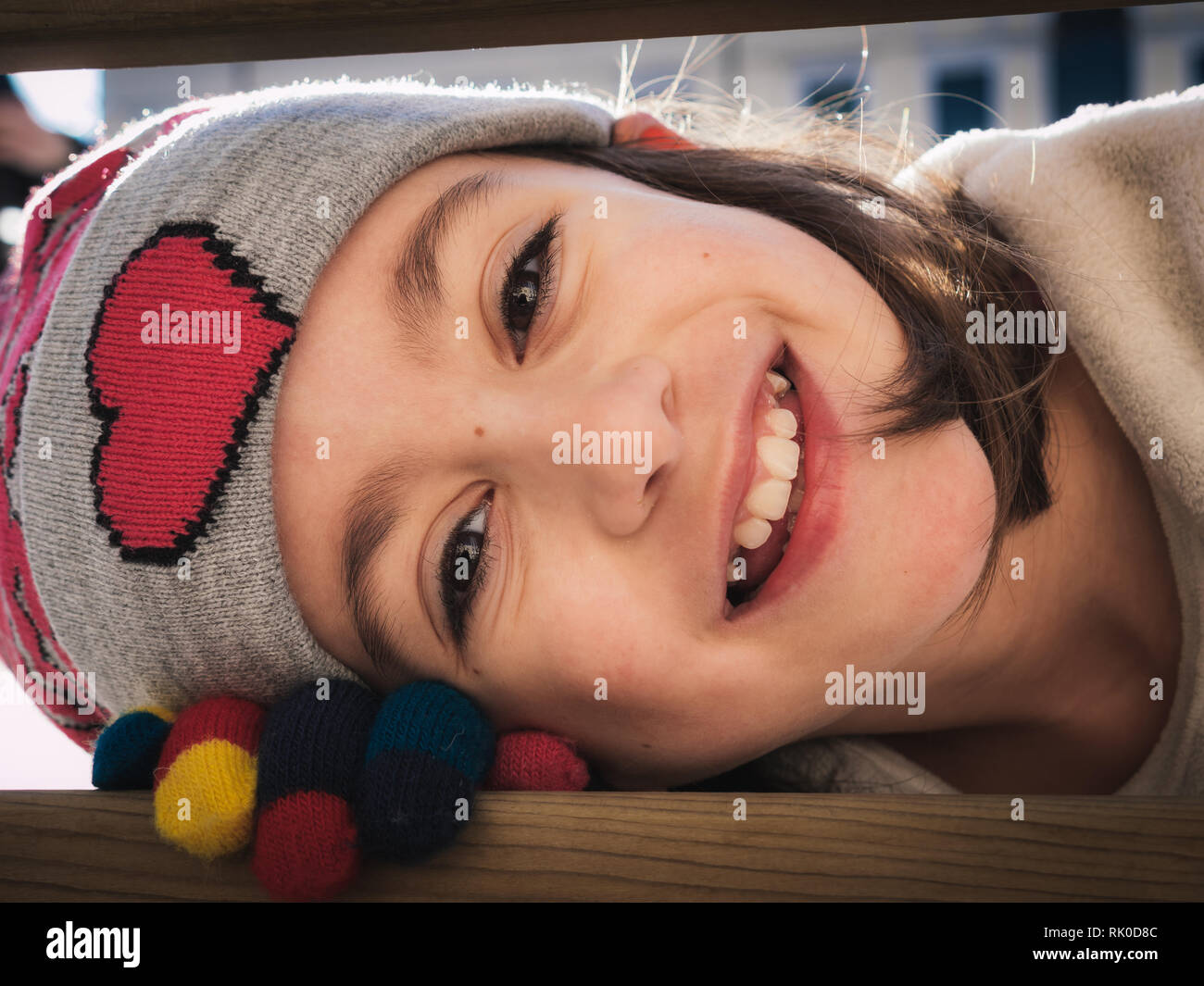 Petite fille de l'hiver portrait. bébé fille sourit et porter des gants et chapeau coloré Banque D'Images