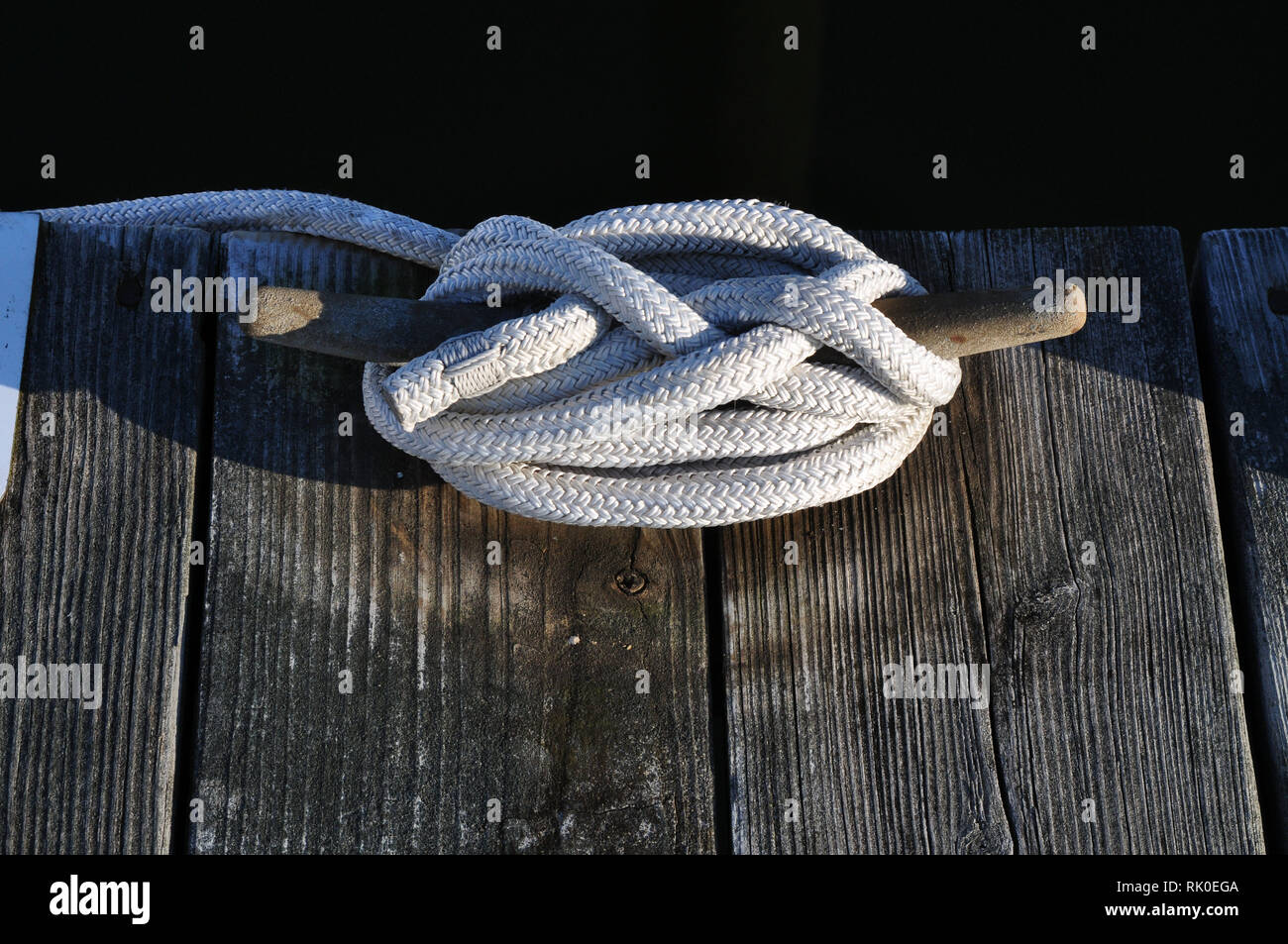 Une cale en métal sur un Dock avec une corde nouée autour de blanc. Banque D'Images