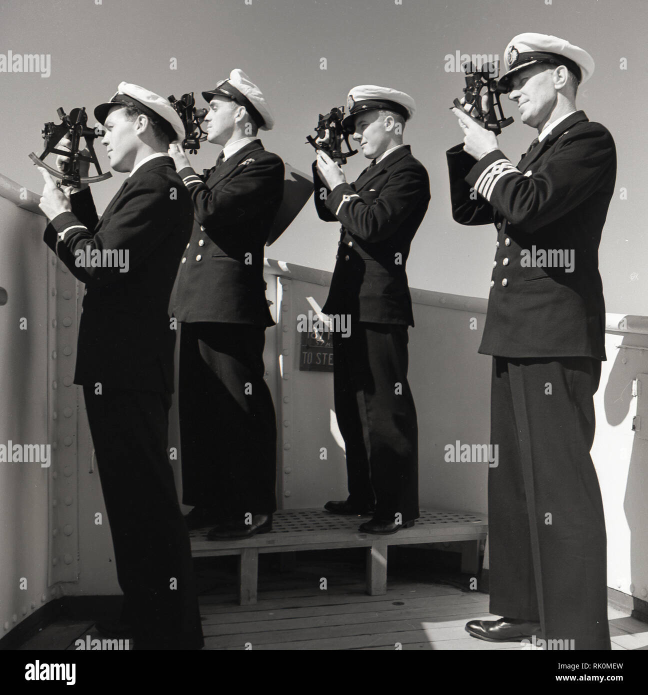 Années 1950, historiques, à l'aide d'officiers de navire en uniforme les sextants, instruments de navigation traditionnelles, sur le pont d'un bateau à vapeur Union-Castle. Banque D'Images